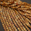 Close-up of heart-shaped beads in various shades of brown and orange.