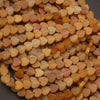 Close-up of heart-shaped beads in various shades of orange and pink.