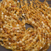 Close-up of amber-colored beads on a string against a dark background