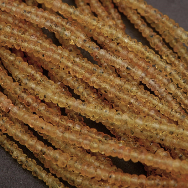 Close-up of amber-colored sapphire beads on a dark background