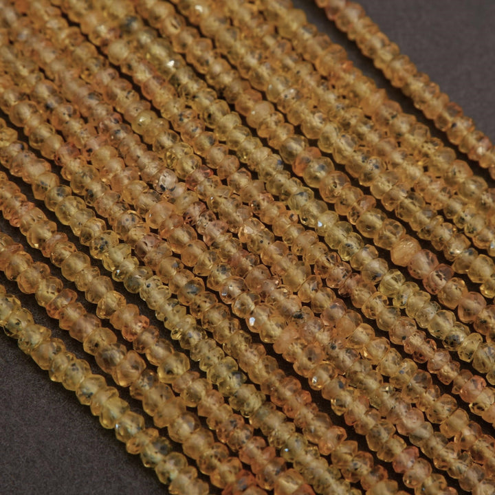 Close-up of a string of small brown beads on a dark background