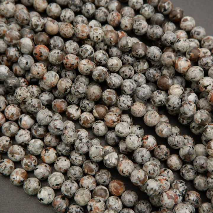Close-up of round beads with a speckled pattern on a gray background
