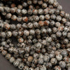 Close-up of a string of small, round beads with a speckled pattern.