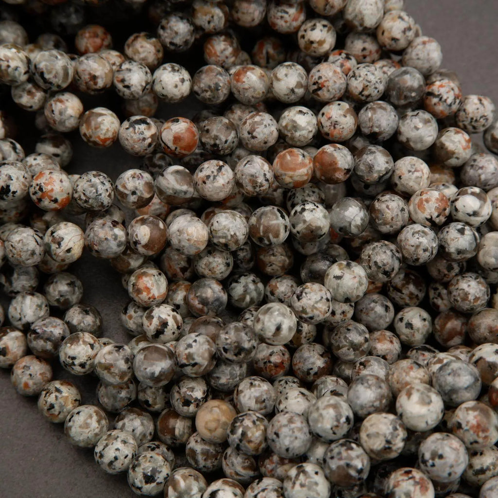 Close-up of a string of small, round beads with a speckled pattern.