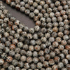 Close-up of round beads with a speckled pattern on a dark surface