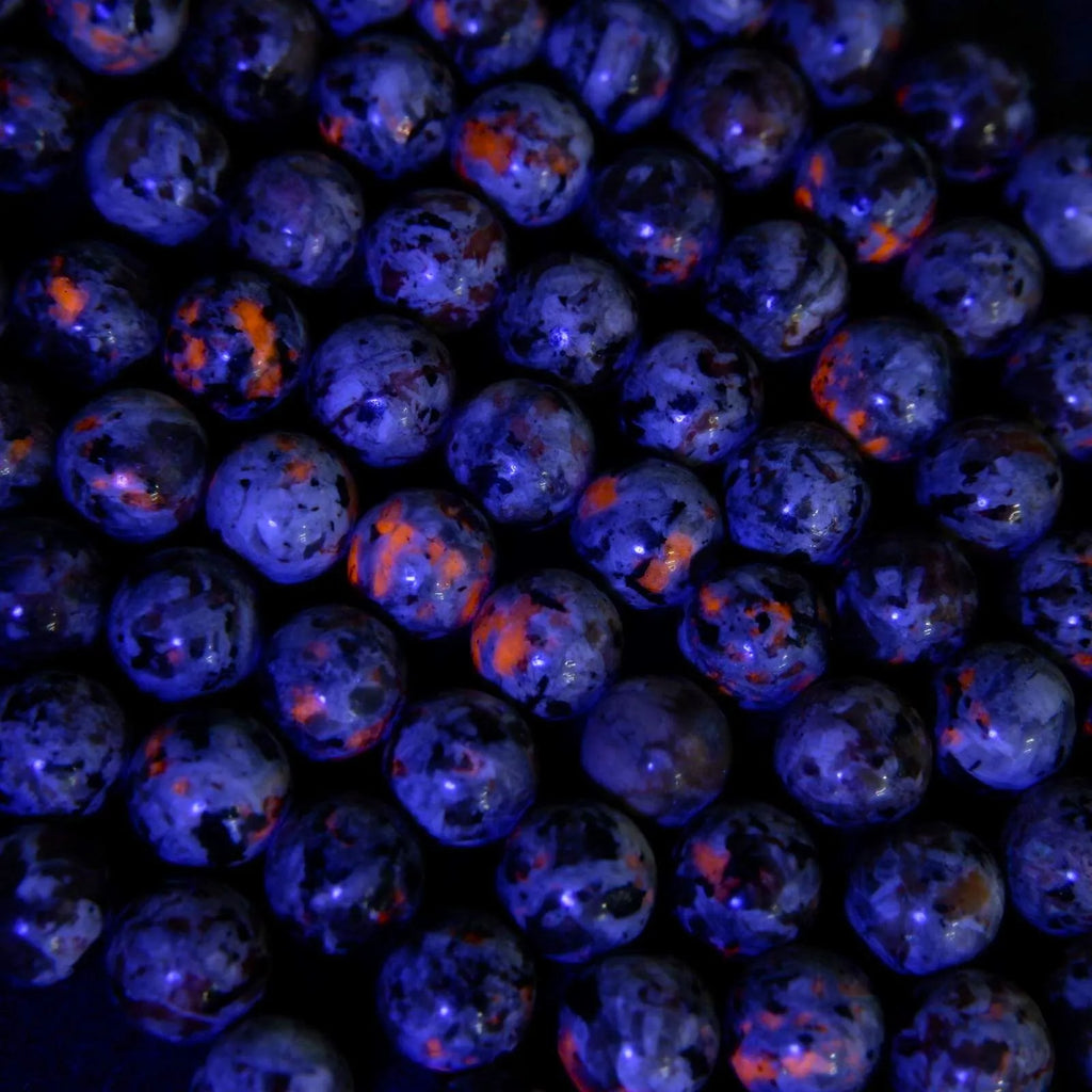 Close-up of blue and orange marbles on a dark background