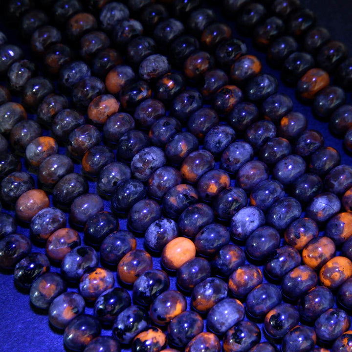 Yooperlite rondelle beads glowing orange under UV light