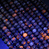 Yooperlite rondelle beads glowing orange under UV light
