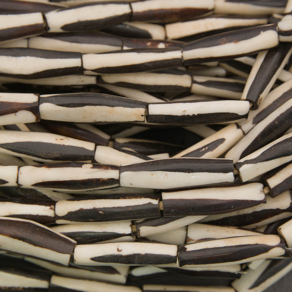 Black and white elongate tube bone beads.