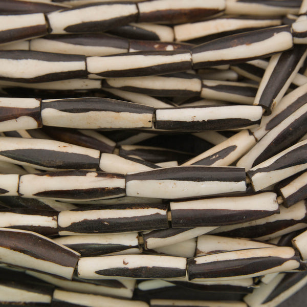 Black and white elongate tube bone beads.