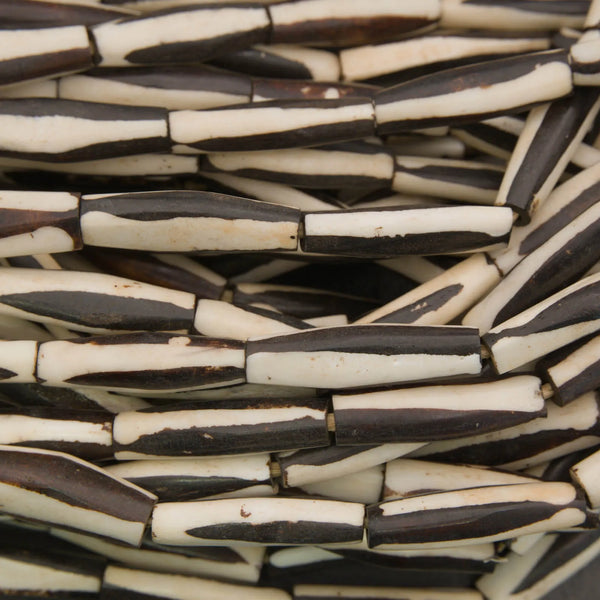 Black and white elongate tube bone beads.