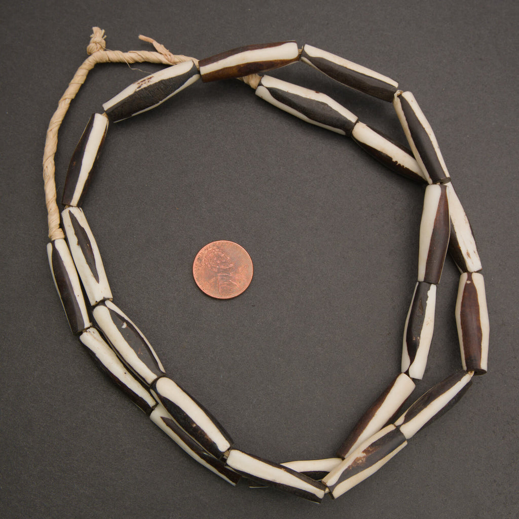 Black and white elongate tube bone beads.