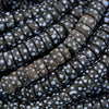 Close-up of dark beads with white speckles arranged in a pattern.