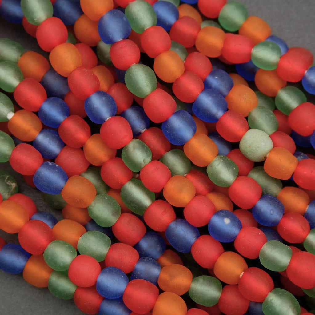 Close-up of colorful beads in red, blue, green, and orange on a gray background