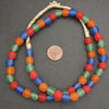 Colorful beaded necklace with a coin for size comparison on a gray background