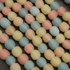 Close-up of pastel-colored round beads on a dark surface