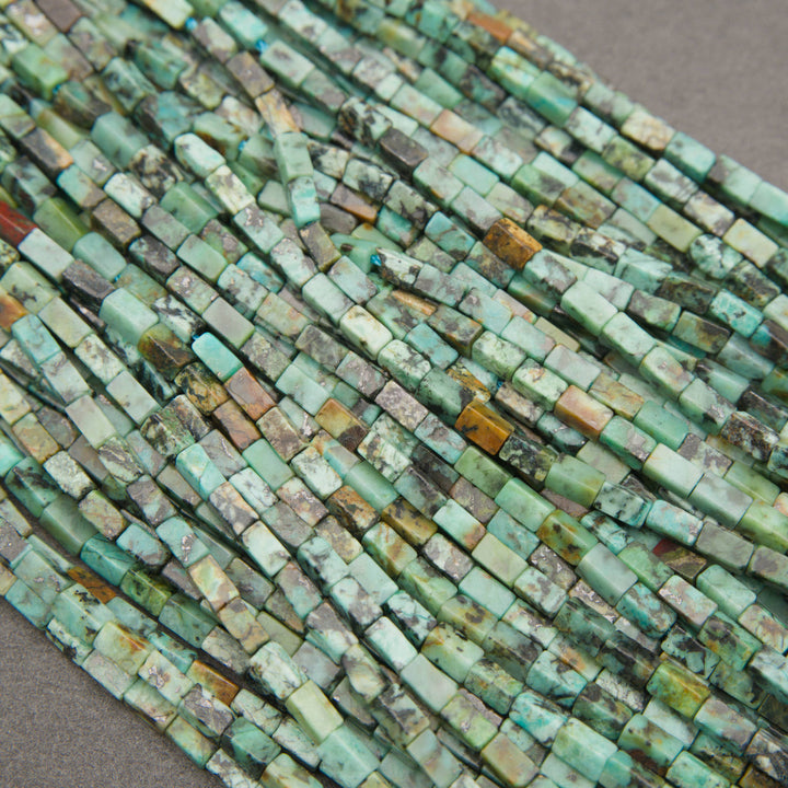 Small African turquoise gemstone tube beads in shades of blue-green, olive, and sandy brown.