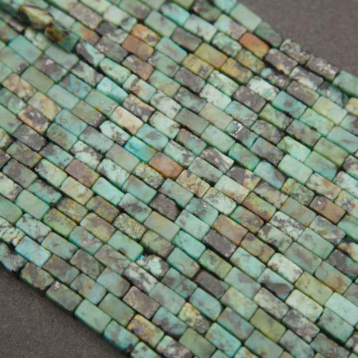Strands of African turquoise rectangular beads with blue-green coloration and contrasting dark matrix.