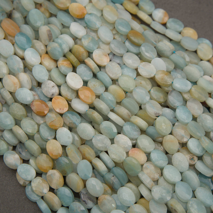 A heap of faceted amazonite oval bead strands in pale aqua, seafoam and peach