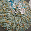 A bundle of faceted amazonite oval bead strands with Tejas Beads tags