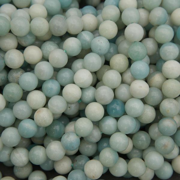 Polished amazonite round beads featuring soft aqua blue, seafoam green, and creamy white tones with natural color variations.