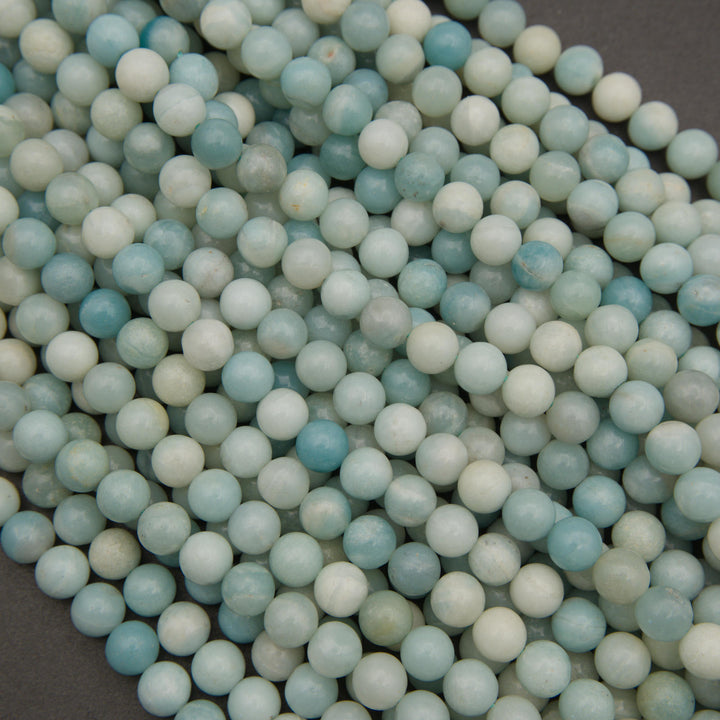 Close-up of natural amazonite gemstone beads showcasing delicate blue-green marbling and a smooth polished surface.