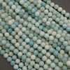 Close-up of natural amazonite gemstone beads showcasing delicate blue-green marbling and a smooth polished surface.