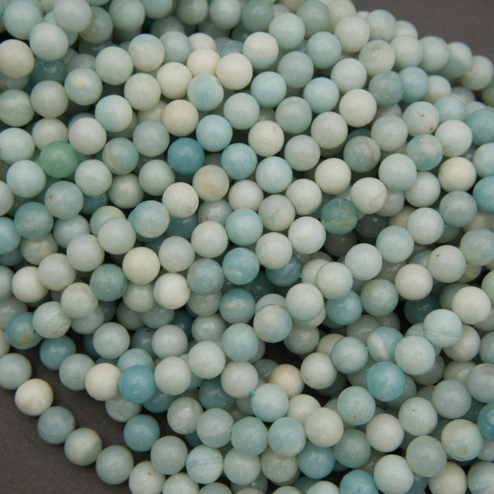 Multiple strands of polished amazonite round beads displaying pastel shades of turquoise, mint green, and ivory.