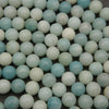 Close-up of polished amazonite round beads highlighting their soft seafoam green hues and natural mineral inclusions.