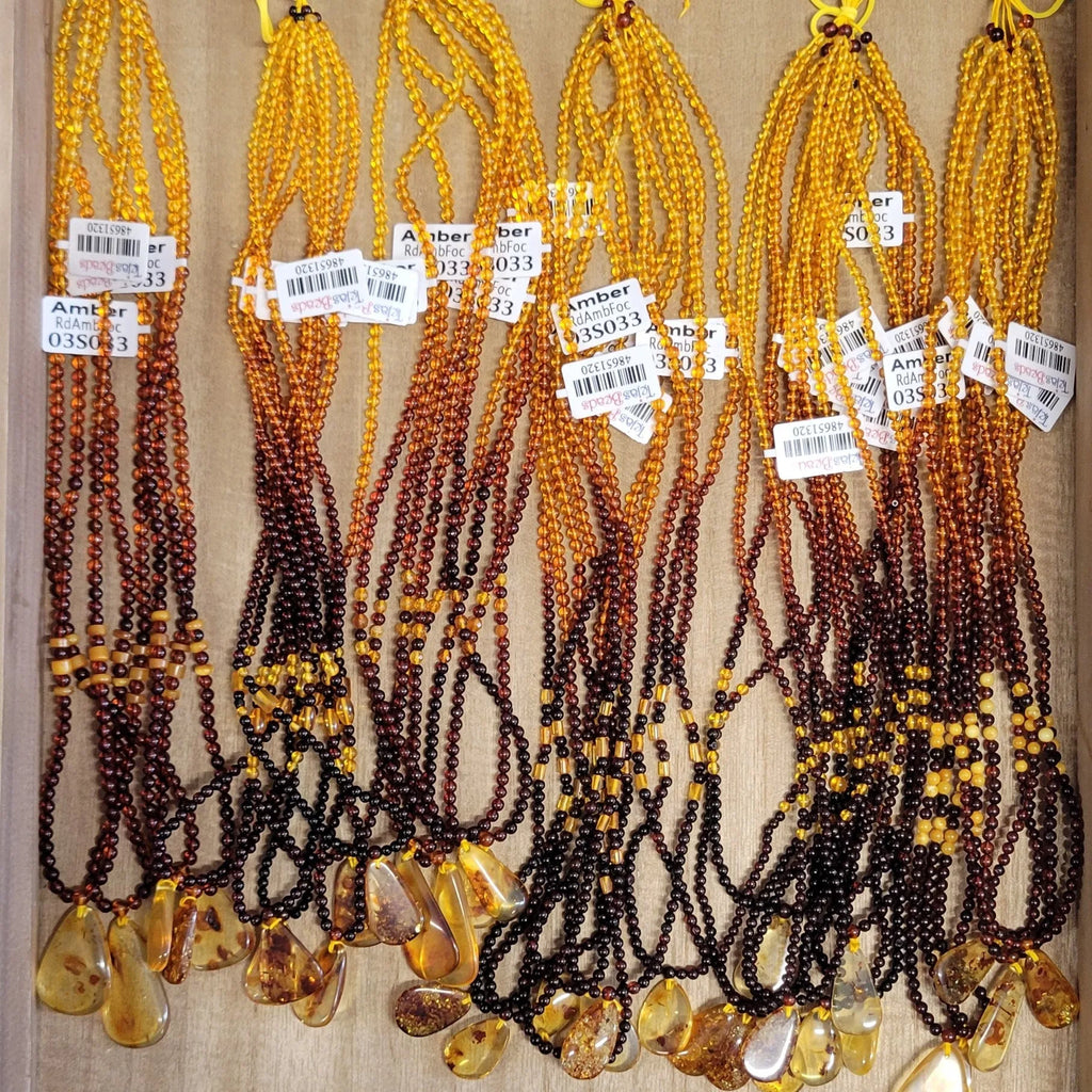 Beaded necklaces with amber stones on a wooden surface
