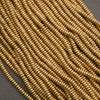 Close-up of a string of gold beads on a dark background