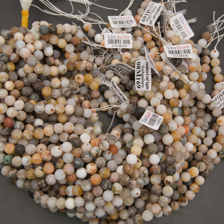 Close-up of Bamboo Leaf Agate beads with cream, brown, and gray markings