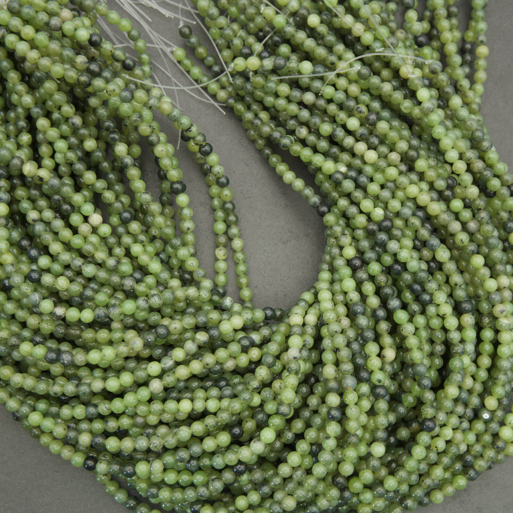 Green jade round beads close up showing natural variation and inclusions