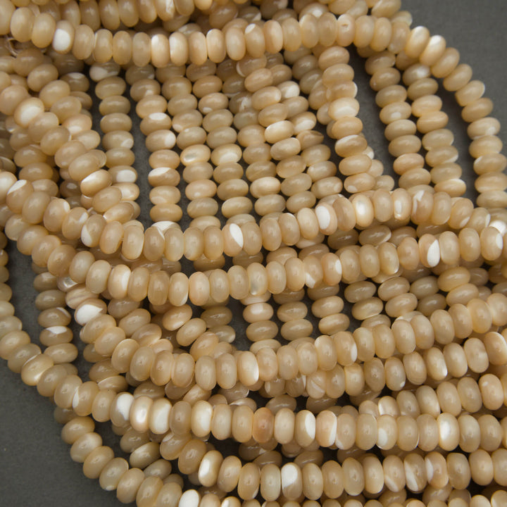 Close-up of a string of beige beads on a gray background