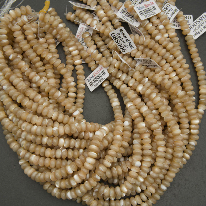 String of beige beads with price tags on a gray surface