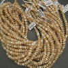 String of beige beads with price tags on a gray surface