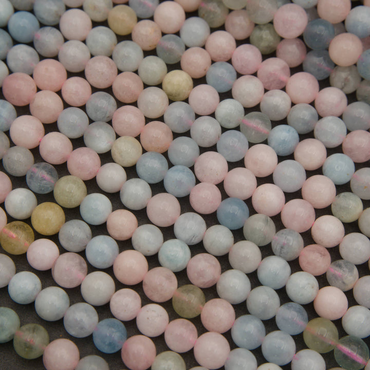 A close-up pile of small round beads in pastel colors, including pink, light blue, pale green, and soft yellow, with a matte finish.