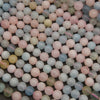 A close-up pile of small round beads in pastel colors, including pink, light blue, pale green, and soft yellow, with a matte finish.