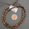 Beaded necklace with a penny for scale on a gray background