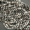 Close-up of a string of black and white beads on a gray background