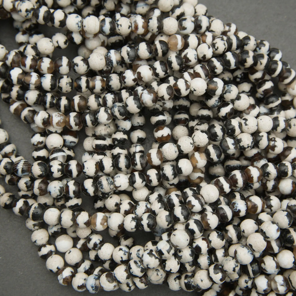 Close-up of a string of black and white beads on a gray background