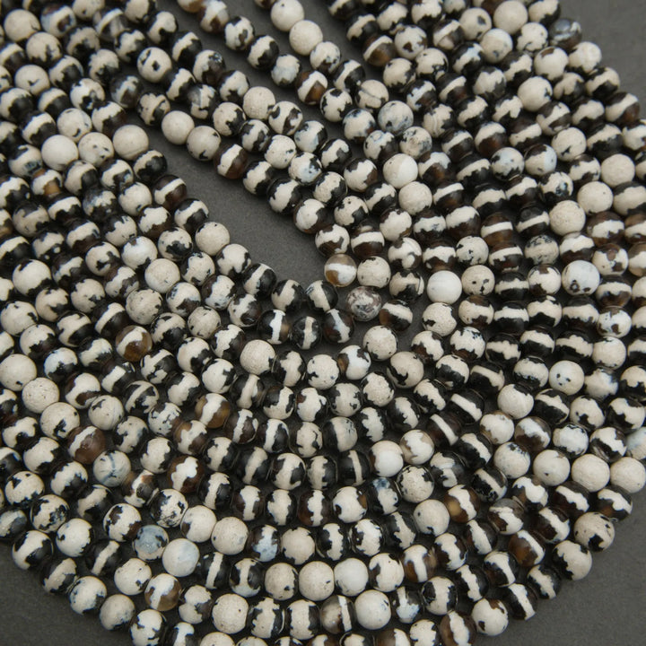 Close-up of a string of black and white beads on a dark background