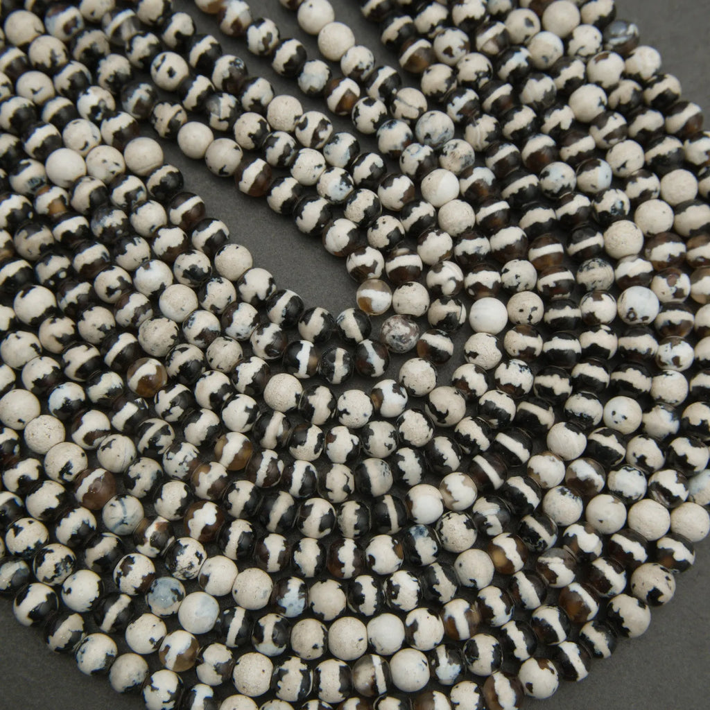 Close-up of a string of black and white beads on a dark background