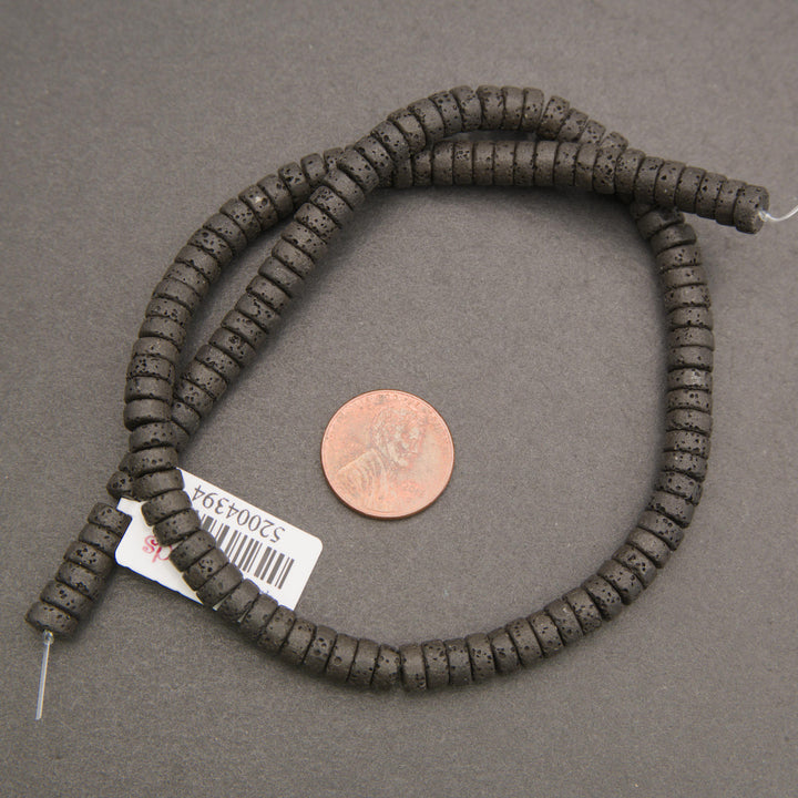 Black volcanic lava rock heishi spacer beads featuring rounded edges and naturally pitted matte surfaces.