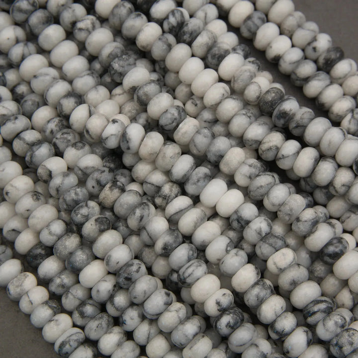 Close-up of white and gray marbled beads on a dark background