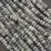 Close-up of white and gray marbled beads on a dark background