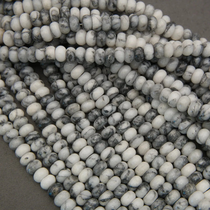 Close-up of a strand of black and white beads on a gray surface