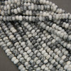 Close-up of a strand of black and white beads on a gray surface