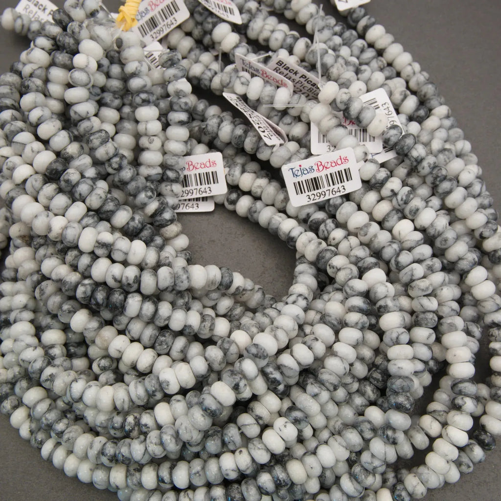 String of gray and white marbled beads with visible brand labels on a gray background