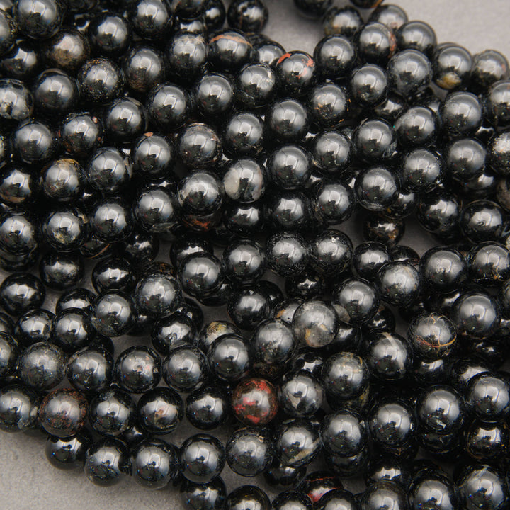 Close-up of Black Tourmaline beads showing natural rust, gray, and brown matrix